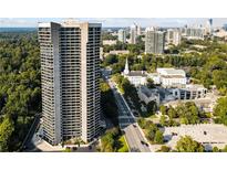 Stunning aerial view showcases the high-rise condo building, surrounded by lush greenery and a vibrant cityscape at 2660 Peachtree Nw Rd # 11G, Atlanta, GA 30305