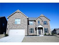 Charming two-story brick home featuring an attached two car garage and a manicured front yard at 301 Eleanora Xing, Loganville, GA 30052