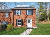 Charming brick two-story home with black shutters and a well-manicured front yard at 185 Willow Stream Ct, Roswell, GA 30076