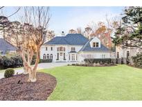 Elegant two-story home boasting a manicured lawn, circular driveway, and timeless architectural details at 3196 Andrews Nw Ct, Atlanta, GA 30305