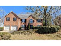 Charming two-story red brick home with a well-manicured lawn and a two-car garage at 5928 Springfair Run, Lithonia, GA 30038