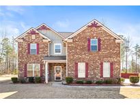 Charming brick two-story home with decorative shutters and well-manicured landscaping at 12348 Hillcrest Dr, Hampton, GA 30228