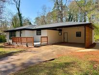 Charming single-story home featuring a painted brick exterior, covered carport, and a welcoming front porch at 2403 Dawn Dr, Decatur, GA 30032