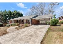 Charming brick home featuring a long driveway and covered carport at 1421 Downs Sw Dr, Atlanta, GA 30311