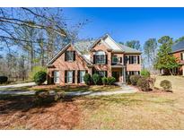 Charming two-story brick home with manicured landscaping and a welcoming front entrance at 305 Collegiate Dr, Powder Springs, GA 30127