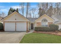 Charming home featuring a two-car garage, stone accents, and well-maintained landscaping at 3175 Justice Mill Nw Ct, Kennesaw, GA 30144