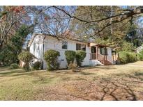 Charming two-story home with white painted brick, a covered porch, and mature trees at 368 Triumph Se Cir, Atlanta, GA 30354