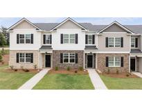 New construction townhomes feature mixed material facade, black shutters and professionally maintained lawn at 452 Reflection Dr # 19, Stockbridge, GA 30281
