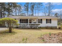 Charming single-story home featuring a cozy front porch and a well-maintained lawn with mature trees at 640 Maple Dr, Riverdale, GA 30274