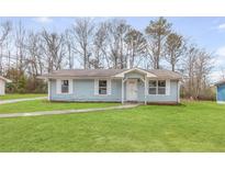 Charming single story home with light blue siding and a well maintained lawn at 8199 Cousins St, Douglasville, GA 30134