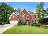 Stately brick home with two-car garage, manicured lawn, and mature trees at 370 Fairleaf Ct, Alpharetta, GA 30022