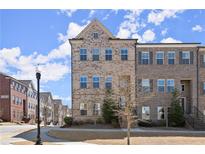 Three-story brick townhouse boasts classic architectural details and well-manicured landscaping at 3724 Via Secco Ln, Suwanee, GA 30024