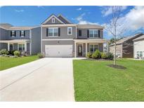 Charming two-story home with well-manicured lawn, concrete driveway, and attached two-car garage at 140 Worthing Ln, Fairburn, GA 30213