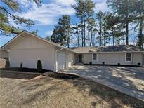 Charming single-story home features a brick exterior, attached garage and a beautifully landscaped front yard at 5520 Morning Creek Cir, Atlanta, GA 30349