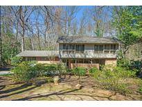 Two-story home featuring a charming brick facade and well-maintained landscaping in a wooded setting at 2124 Azalea Cir, Decatur, GA 30033
