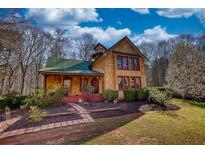 Charming two-story home with a landscaped yard, a green roof, and eye-catching windows at 5642 N Highway 212, Covington, GA 30016