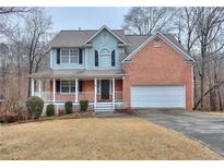 Charming two-story home with a welcoming front porch and a well-maintained lawn and attractive brick and siding facade at 1665 Reynolds Mill Dr, Lawrenceville, GA 30043