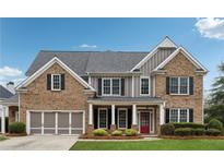 Charming two-story brick home featuring black shutters, a red front door, and a well-manicured lawn at 4776 Trilogy Park Trl, Hoschton, GA 30548