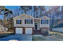 Charming two-story home features a two-car garage and a beautifully landscaped front yard at 7021 Hillcrest Chase Ln, Austell, GA 30168