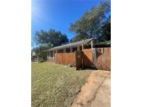 Cozy single-story home featuring a fenced yard and mature trees on a sunny day at 1155 Welch Sw St, Atlanta, GA 30310