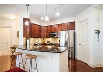 Modern kitchen with stainless steel appliances, breakfast bar, and dark wood cabinets at 200 River Vista Dr # 736, Atlanta, GA 30339