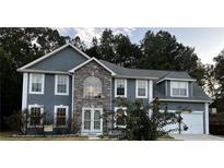 Two-story home featuring stone accents, double garage, neutral paint, and well-maintained landscaping at 1583 Rogers Crossing Dr, Lithonia, GA 30058