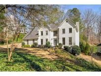 Charming white brick home with a well-manicured front yard and mature trees, offering great curb appeal at 2115 Azalea Dr, Roswell, GA 30075