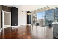 Spacious living room featuring hardwood floors, floor to ceiling windows, and modern chandelier at 1065 Peachtree Ne St # 2901, Atlanta, GA 30309