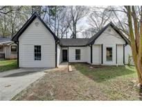 Charming one story home with white siding, black trim and a concrete driveway at 5393 Ridge Forest Dr, Stone Mountain, GA 30083