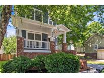 Charming two-story home showcasing a welcoming front porch with brick accents and manicured landscaping at 609 Old Wheat Ne St, Atlanta, GA 30312