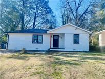 Charming single-story house featuring a fresh white painted brick, dark trim and a well-manicured front yard at 53 Springside Se Dr, Atlanta, GA 30354