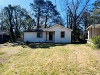 Charming single-story house featuring a painted brick facade and a well-maintained lawn at 53 Springside Se Dr, Atlanta, GA 30354