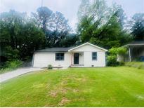 Charming single-story home featuring a freshly painted exterior, lush green lawn, and a welcoming entrance at 53 Springside Se Dr, Atlanta, GA 30354