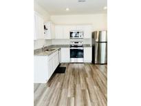 Bright kitchen features stainless steel appliances, granite counters, and hardwood floors at 2633 Coventry Sw St, Atlanta, GA 30331