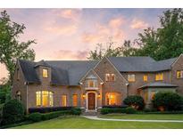 Stunning brick home showcasing manicured lawn, mature landscaping, and a welcoming entrance at dusk at 4520 Garmon Nw Rd, Atlanta, GA 30327