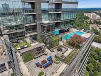 Upscale rooftop patio featuring an outdoor fireplace, dining area, lounge seating and access to community pool at 3630 Peachtree Ne Rd # 3302, Atlanta, GA 30326