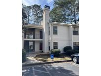 Well-maintained condo with a cream exterior and parking, surrounded by mature trees at 2611 Huntingdon Chase, Atlanta, GA 30350