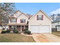 Charming two-story home with red shuttered windows, attached two car garage, and manicured landscaping at 345 Timberlake Ter, Covington, GA 30016