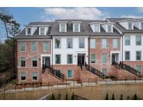 Beautiful townhome exterior with brick facade, white siding, and well-maintained landscaping at , Alpharetta, GA 30009