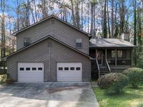 Charming two-story home with a two-car garage and a welcoming front porch in a wooded setting at 4525 Hickory Grove Nw Dr, Acworth, GA 30102