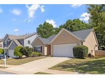 Charming single-Gathering home with a two-car garage and a well-maintained lawn in a suburban neighborhood at 310 Tuggle Court, Woodstock, GA 30188