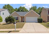 Charming single-story home featuring manicured lawn, neutral siding, and an attached two-car garage at 310 Tuggle Court, Woodstock, GA 30188