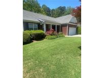 Charming single-story home with well-manicured lawn and mature landscaping at 564 Grand Ashbury Ln, Buford, GA 30518