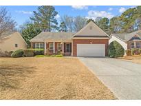 Charming single-story brick home featuring an attached garage and a well-manicured lawn in a desirable neighborhood at 564 Grand Ashbury Ln, Sugar Hill, GA 30518