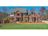 Charming two-story brick home with a well-manicured lawn and mature landscaping at 3718 Thunder Ne Way, Marietta, GA 30066