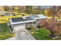 Charming home with solar panels, a metal roof, a garage, landscaping, and a large yard at 5320 Karr Rd, Cumming, GA 30040
