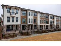Modern townhome exteriors with mixed brick and board and batten and black framed windows at 334 Olmstead Way # 37, Alpharetta, GA 30022