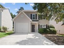 Charming two-story home featuring a well-maintained lawn, a single-car garage, and a classic neutral exterior at 162 Springbottom Dr, Lawrenceville, GA 30046