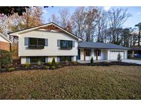 Charming home featuring a manicured lawn, contrasted with a white and gray facade, and a two car garage at 175 Jayne Ellen Way, Alpharetta, GA 30009