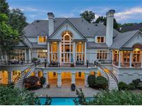 Stunning rear view of the home with a pool and deck, featuring beautiful architectural details and a spacious outdoor living area at 510 Covington Cv, Alpharetta, GA 30022